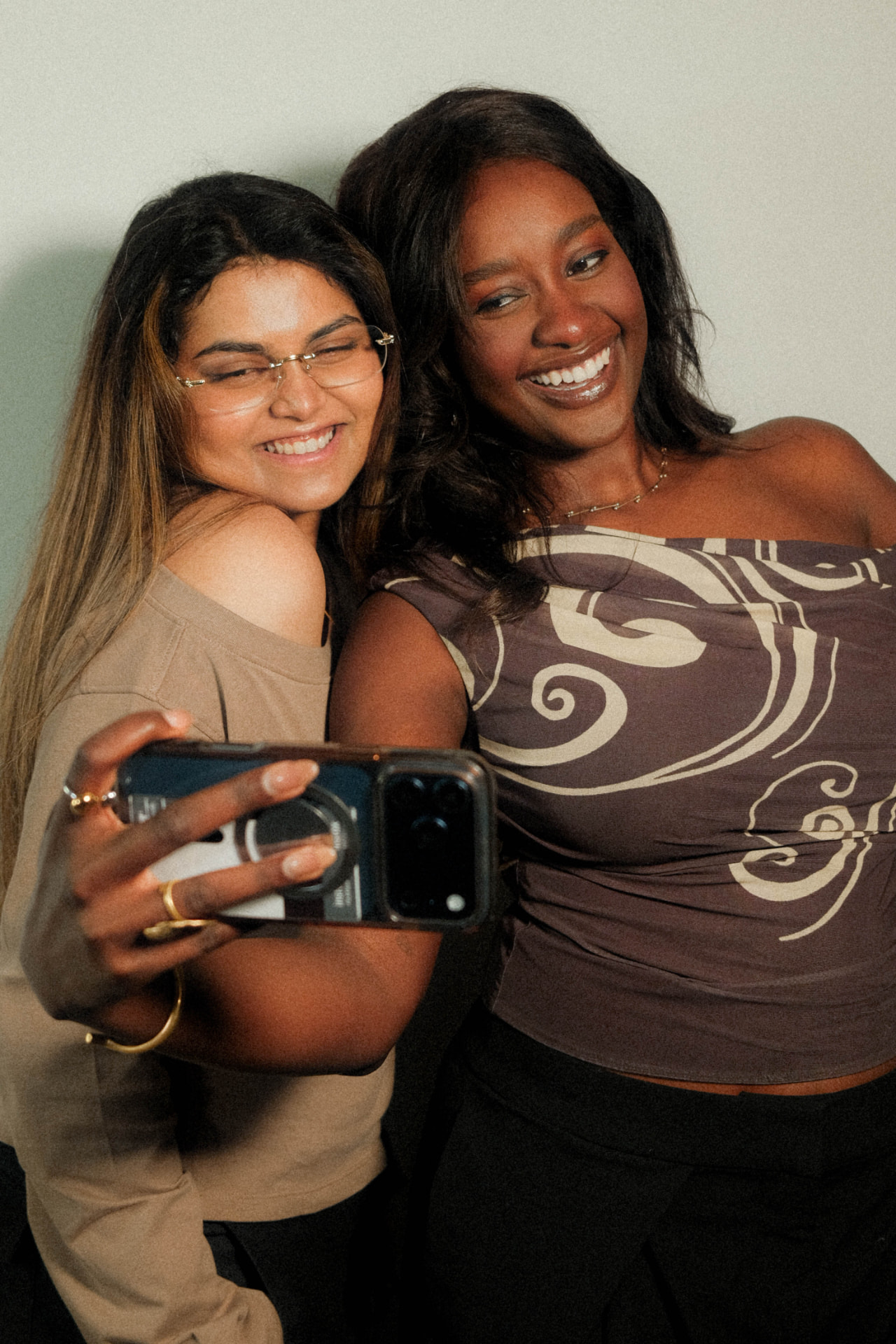 Shalom and Nithya smiling together for a mirror selfie, with Nithya holding a phone
